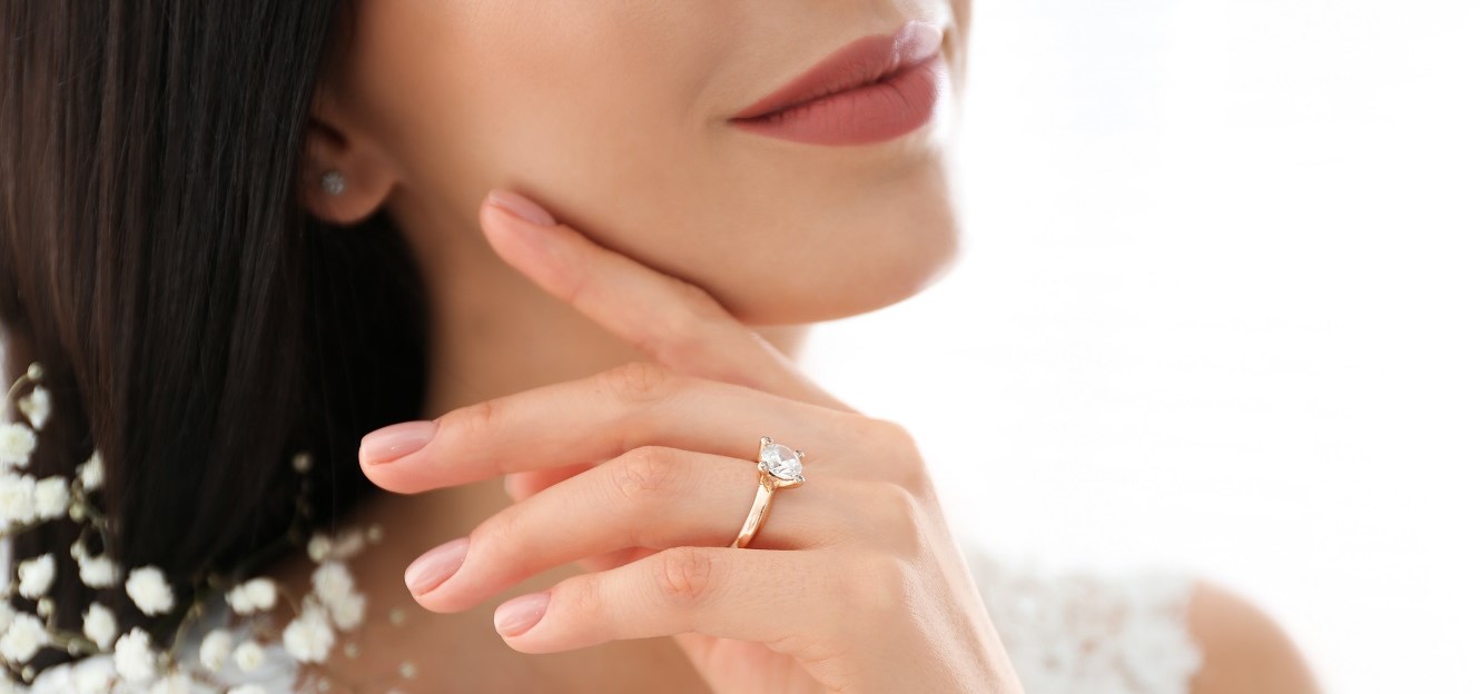 Bride waring a diamond engagement ring and diamond stud earrings