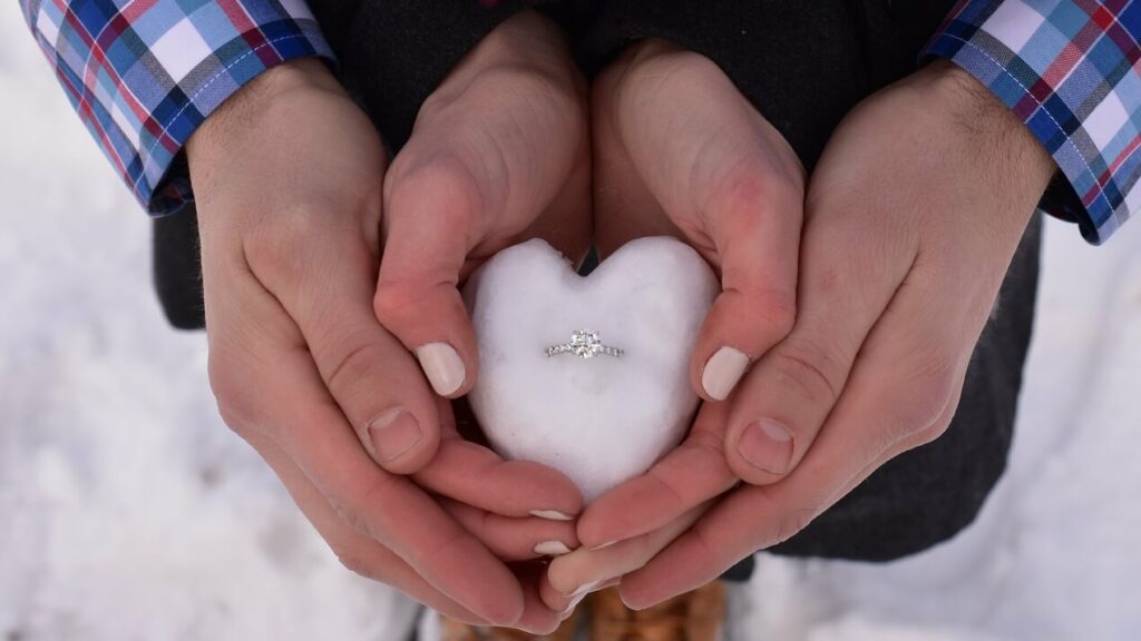 A man proposing in the snow with an affordable diamond engagement ring